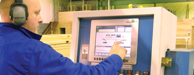 Worker programming a machine inside the workshop